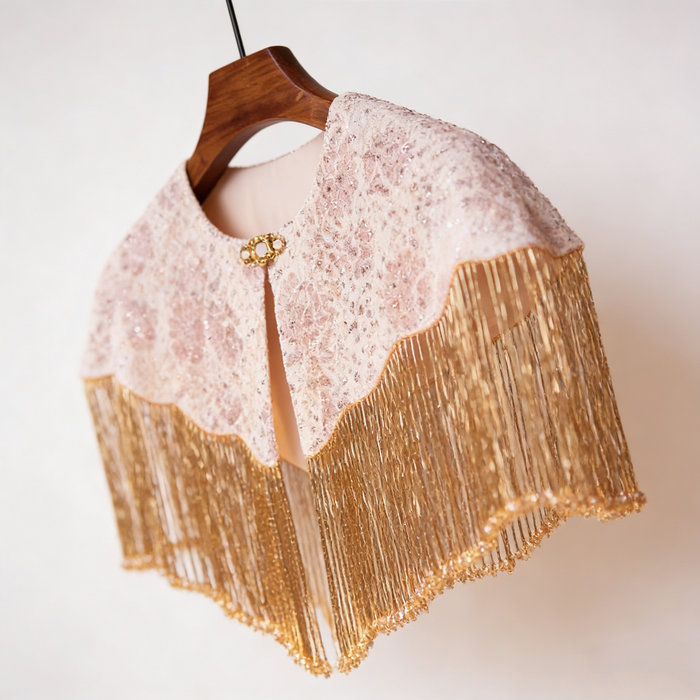 Handmade bridal shoulder cape featuring champagne gold fringe, blush embroidery, shimmering sequins, and delicate seed bead embellishments.