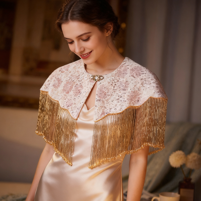 Elegant champagne gold bridal cape with handcrafted bead embroidery and flowing fringe for weddings and evening occasions.