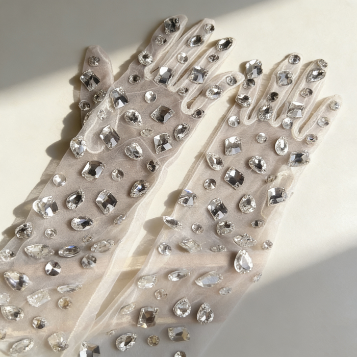 Handmade mid-length bridal gloves crafted from sheer tulle and decorated with individually hand sewn crystal rhinestones.