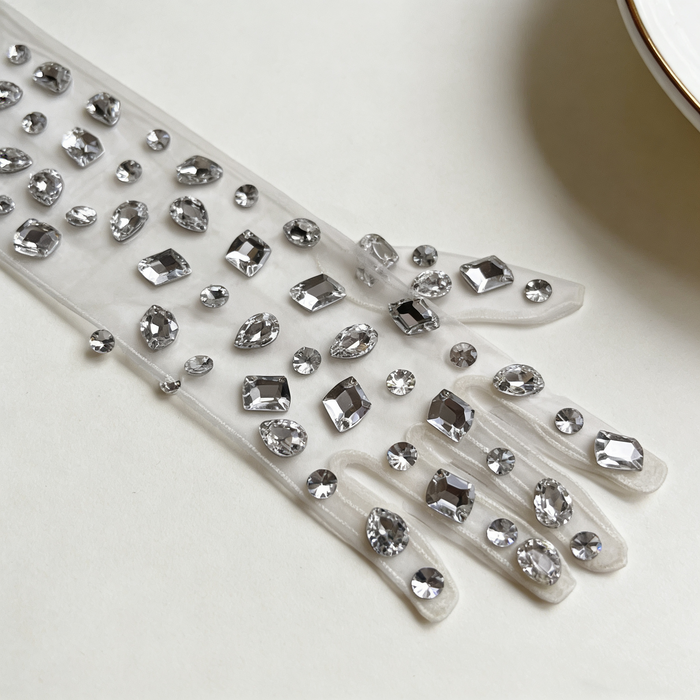 Handmade mid-length bridal gloves crafted from sheer tulle and decorated with individually hand sewn crystal rhinestones.