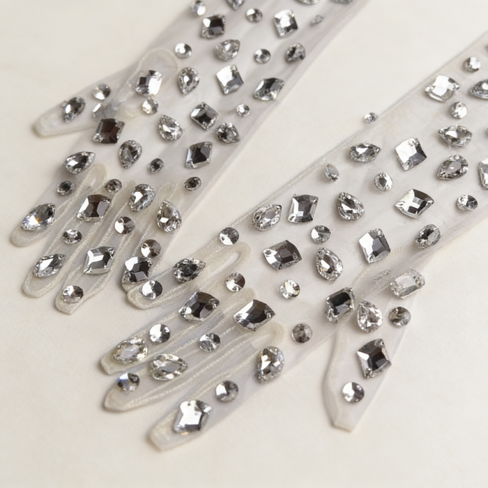 Elegant crystal embellished tulle wedding gloves featuring sparkling hand sewn rhinestones for modern bridal styling.