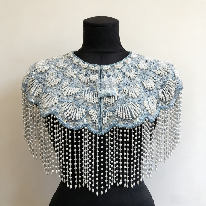Elegant bridal shoulder cape featuring shimmering ice blue bead embroidery and flowing pearl fringe.