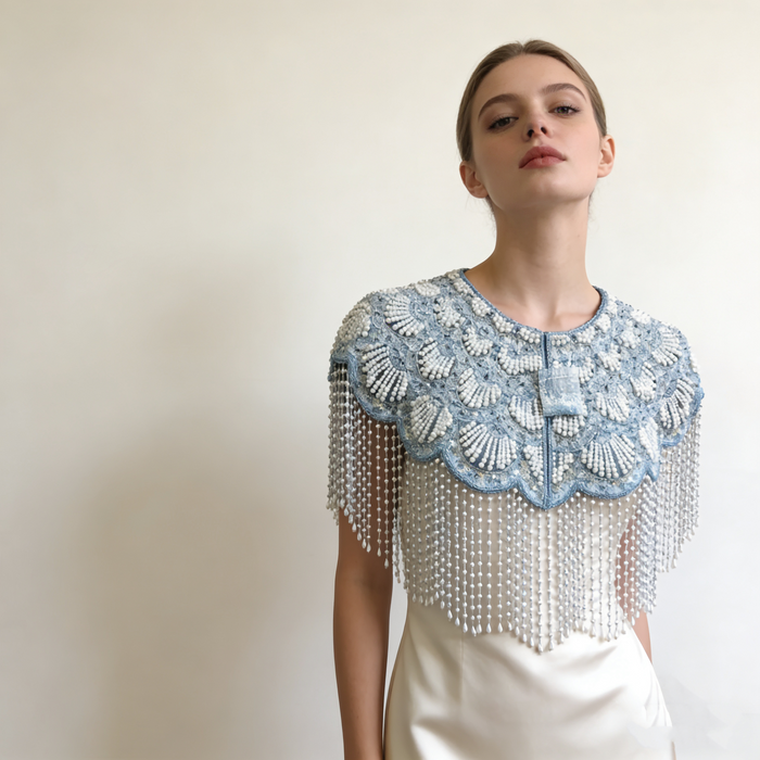 Elegant bridal shoulder cape featuring shimmering ice blue bead embroidery and flowing pearl fringe.
