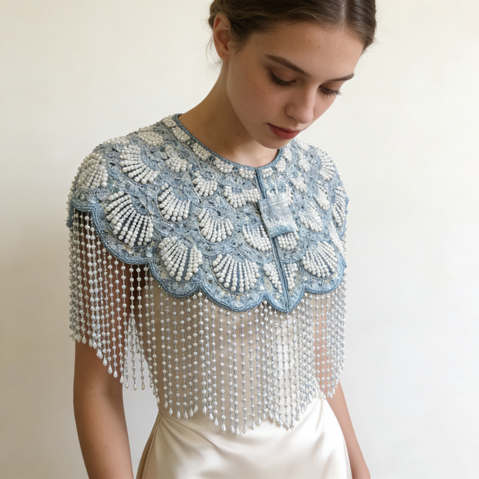 Elegant bridal shoulder cape featuring shimmering ice blue bead embroidery and flowing pearl fringe.