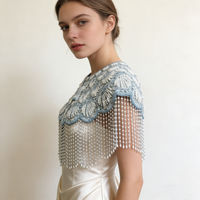 Elegant bridal shoulder cape featuring shimmering ice blue bead embroidery and flowing pearl fringe.