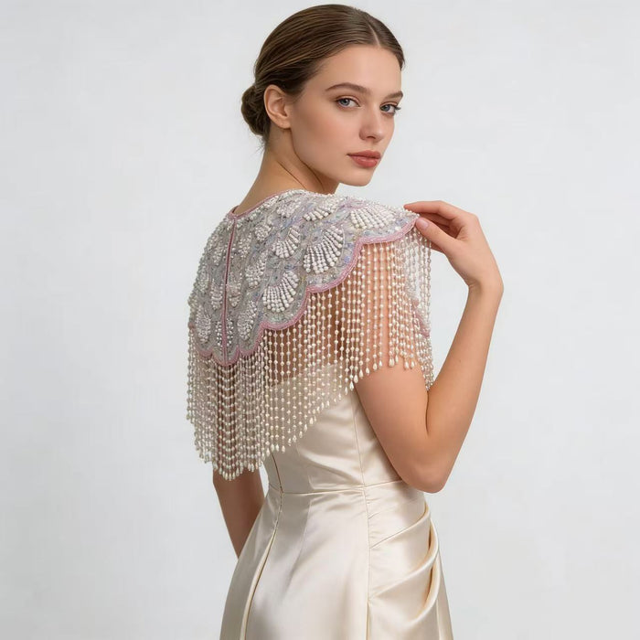 Elegant bridal shoulder cape with shell-inspired bead embroidery, shimmering sequins, and flowing pearl fringe.