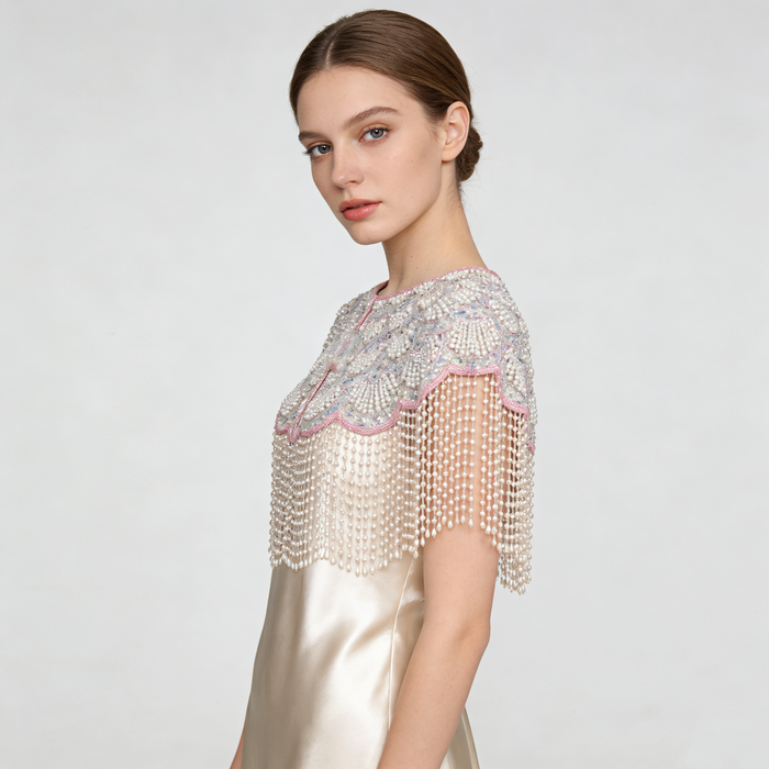 Elegant bridal shoulder cape with shell-inspired bead embroidery, shimmering sequins, and flowing pearl fringe.