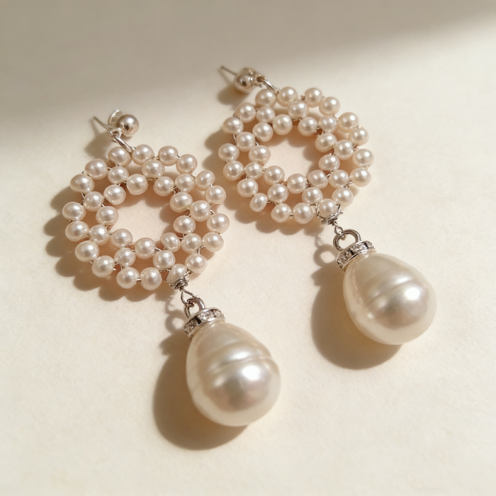Elegant bridal statement earrings handcrafted with genuine freshwater pearls in a woven circular design and baroque pearl drop.