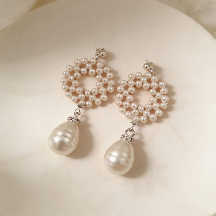 Elegant bridal statement earrings handcrafted with genuine freshwater pearls in a woven circular design and baroque pearl drop.