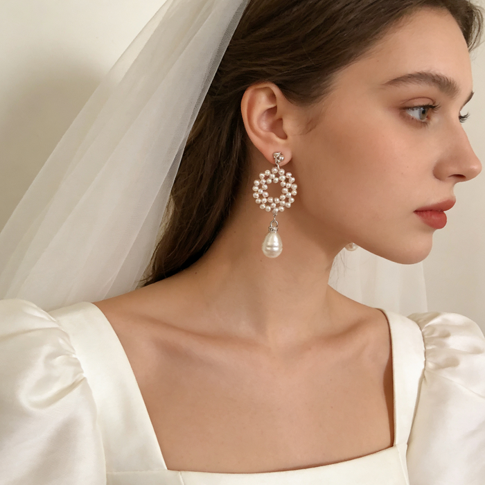 Elegant bridal statement earrings handcrafted with genuine freshwater pearls in a woven circular design and baroque pearl drop.