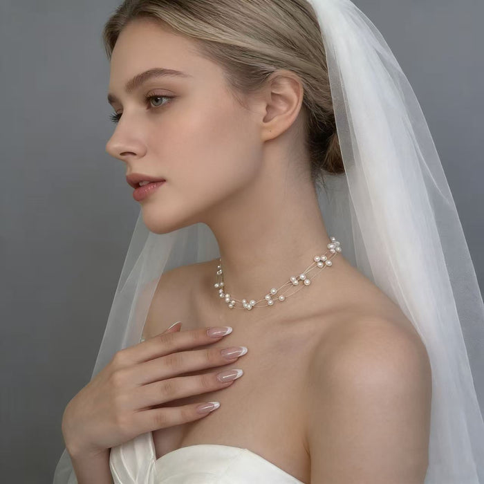 Handmade adjustable layered necklace featuring genuine freshwater pearls and 14K gold-plated hardware for elegant bridal styling.