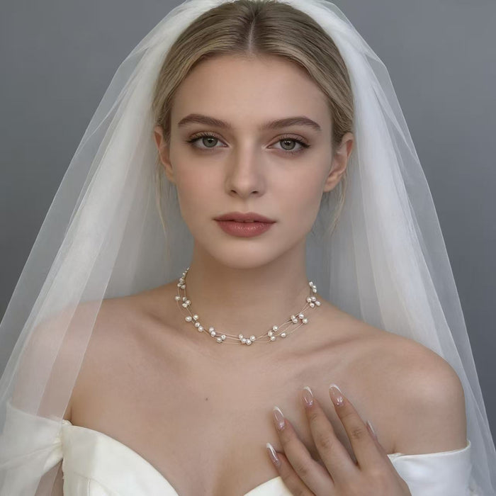 Natural freshwater pearl bridal choker with delicate floating multi-strand design and adjustable clasp for weddings and special occasions.