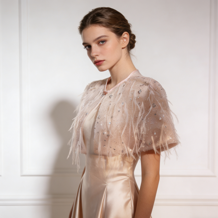 Luxury feather wedding shoulder cape with sparkling sequins and airy nude tulle for elegant bridal styling.