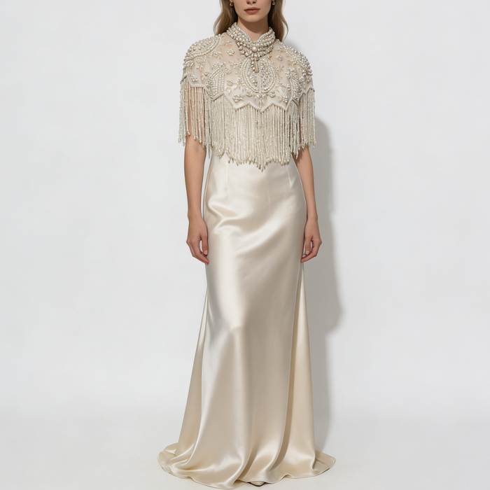 Handmade illusion tulle bridal cape embroidered with faux pearls, floral beadwork, and elegant pearl fringe.