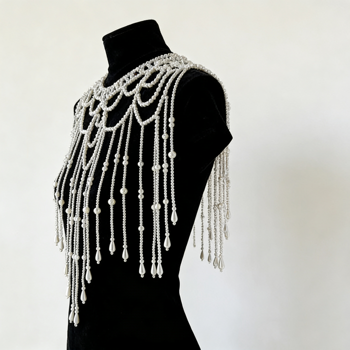 Elegant bridal pearl capelet with hand-beaded shoulder drapes, delicate fringe, and luxury wedding jewelry styling.