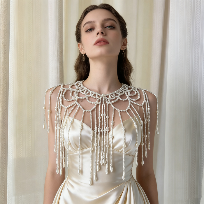 Elegant bridal pearl capelet with hand-beaded shoulder drapes, delicate fringe, and luxury wedding jewelry styling.