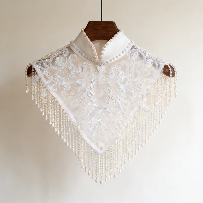 Handmade bridal cape featuring illusion tulle, pearl bead embroidery, shimmering sequins, and elegant pearl fringe.