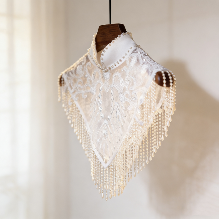 Handmade bridal cape featuring illusion tulle, pearl bead embroidery, shimmering sequins, and elegant pearl fringe.