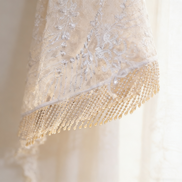 Handmade bridal cape featuring illusion tulle, pearl bead embroidery, shimmering sequins, and elegant pearl fringe.