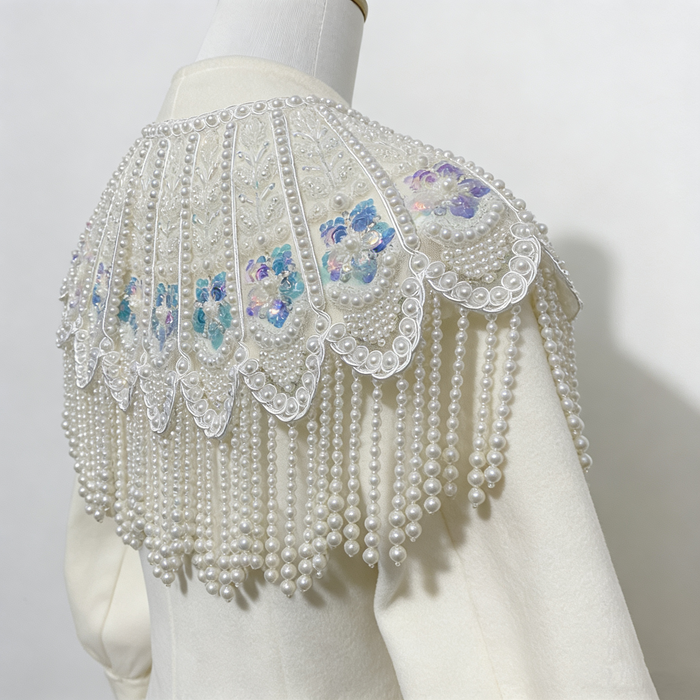 Handmade bridal cape featuring hand-sewn sequin bead embroidery, iridescent floral details, and cascading faux pearl fringe.