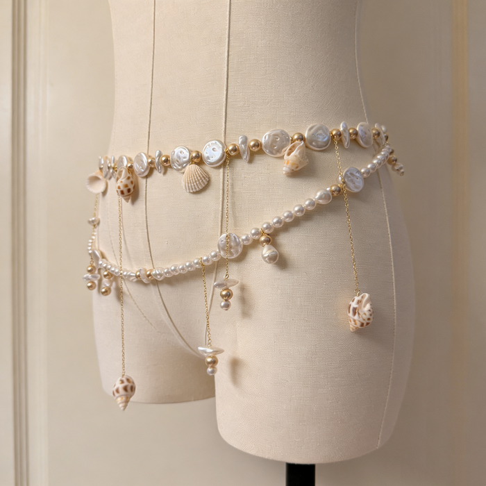 Handmade bridal waist belt featuring imitation pearls, natural seashell charms, layered gold chains, and elegant pearl tassels.