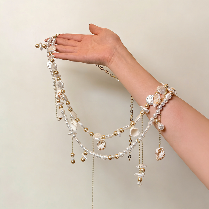 Handmade bridal waist belt featuring imitation pearls, natural seashell charms, layered gold chains, and elegant pearl tassels.
