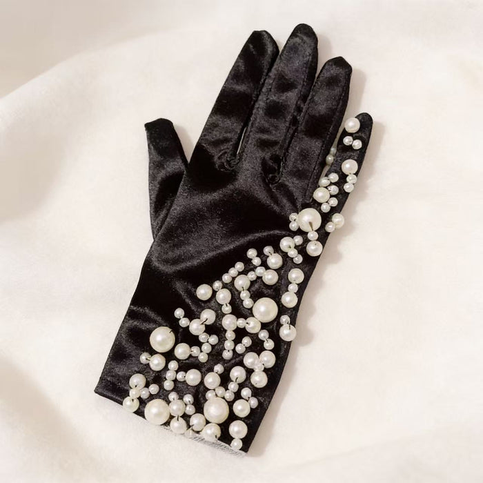 Handmade black velvet gloves featuring hand-sewn faux pearl embellishments in an elegant Hepburn-inspired design.