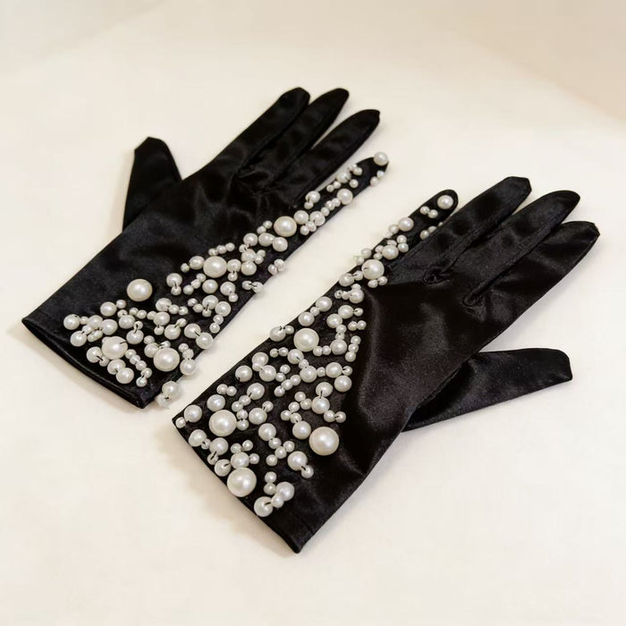 Handmade black velvet gloves featuring hand-sewn faux pearl embellishments in an elegant Hepburn-inspired design.