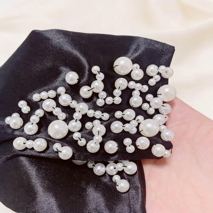 Handmade black velvet gloves featuring hand-sewn faux pearl embellishments in an elegant Hepburn-inspired design.