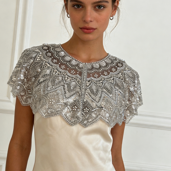 Handmade silver bridal capelet with intricate bead embroidery, shimmering sequins, and scalloped edges.