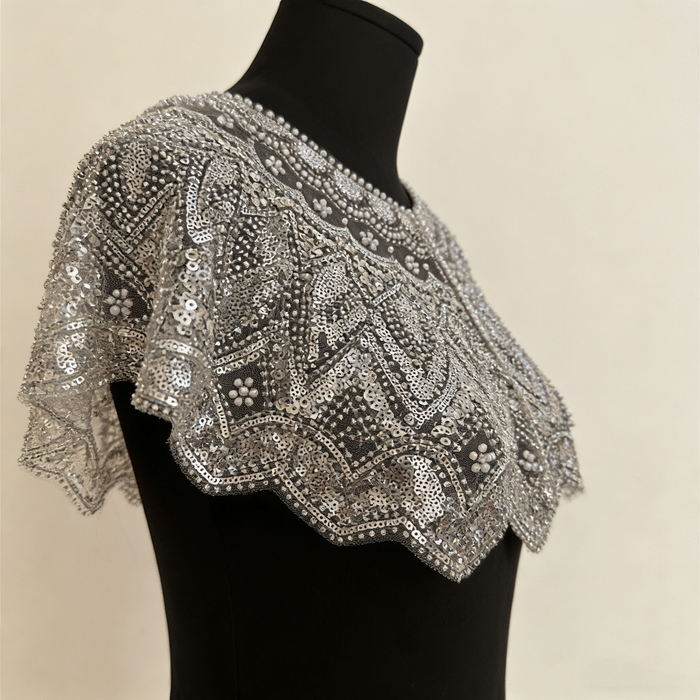 Handmade silver bridal capelet with intricate bead embroidery, shimmering sequins, and scalloped edges.