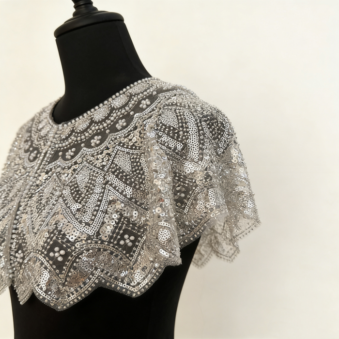 Handmade silver bridal capelet with intricate bead embroidery, shimmering sequins, and scalloped edges.