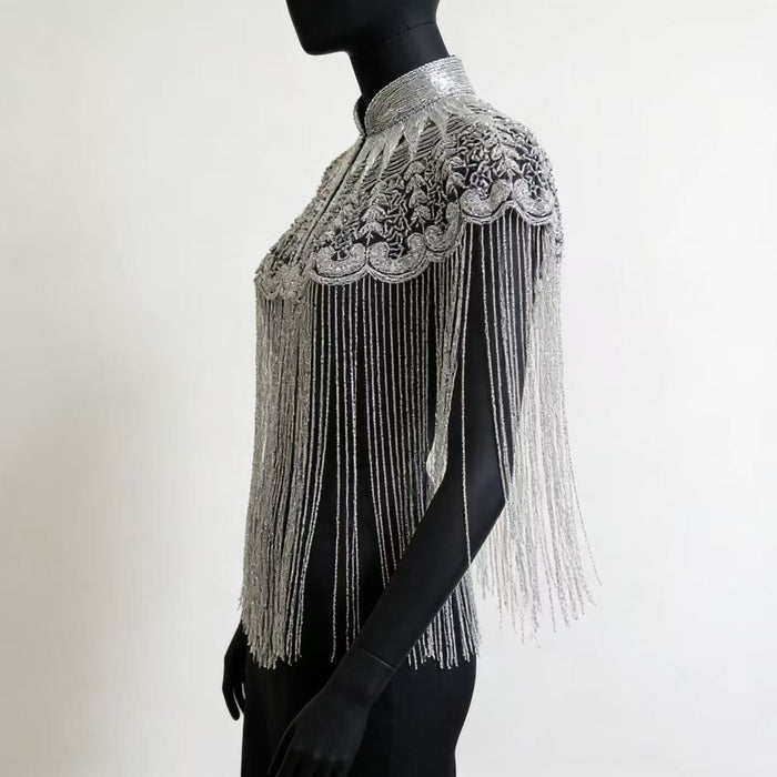 Handmade silver bridal cape featuring intricate bead embroidery, shimmering sequins, seed beads, and flowing metallic fringe.