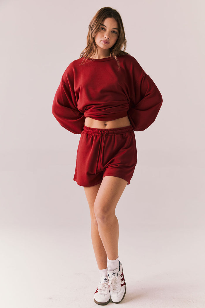 Crimson red drawstring lounge shorts in pillow terry fabric.