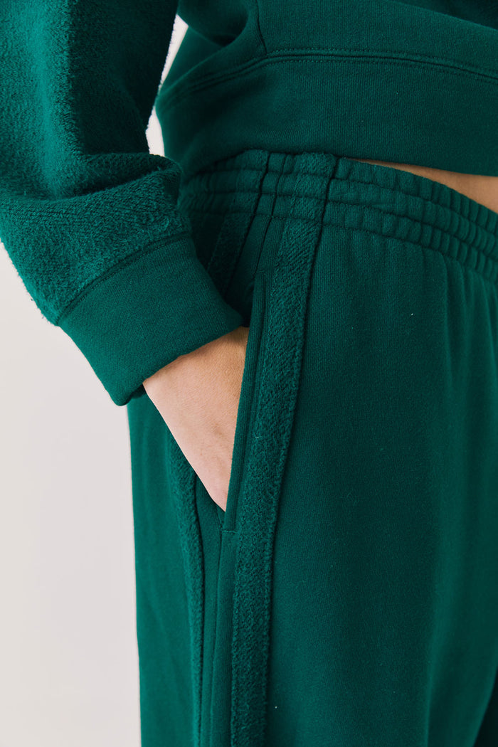 Front view of woman wearing Chaser’s Hazel Joggers in Blue Grass Green on a white background