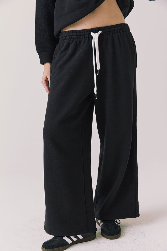Front view of woman wearing Chaser’s Hazel Joggers in true black on a white background