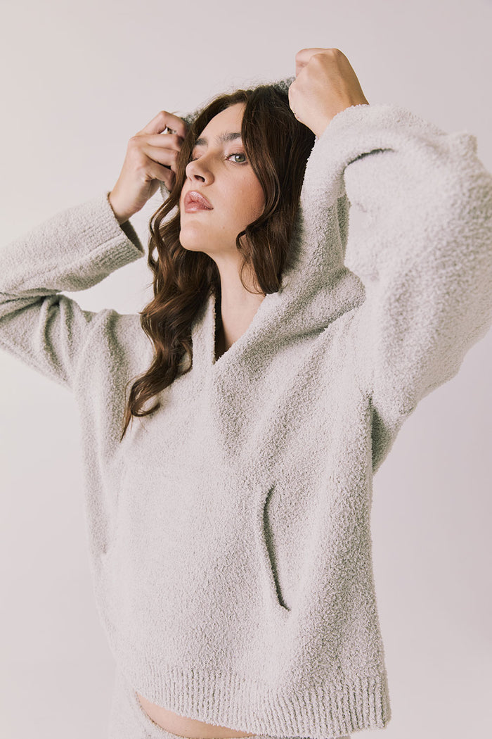 Side view of woman wearing Chaser’s Hazen Heather Grey Pullover Hoodie on a white background