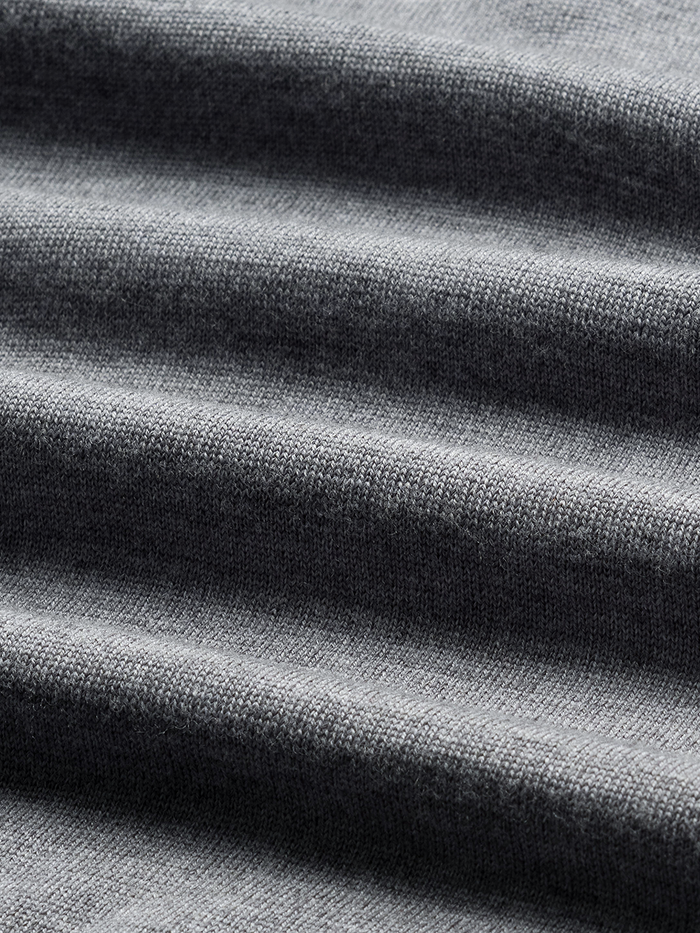 Close-up of heather grey quarter-zip sweater knit fabric with soft folds