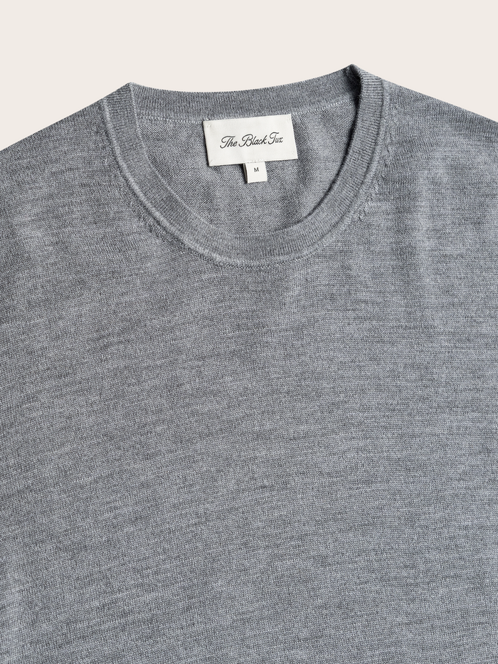 Close-up of heather grey crew sweater neckline and brand label