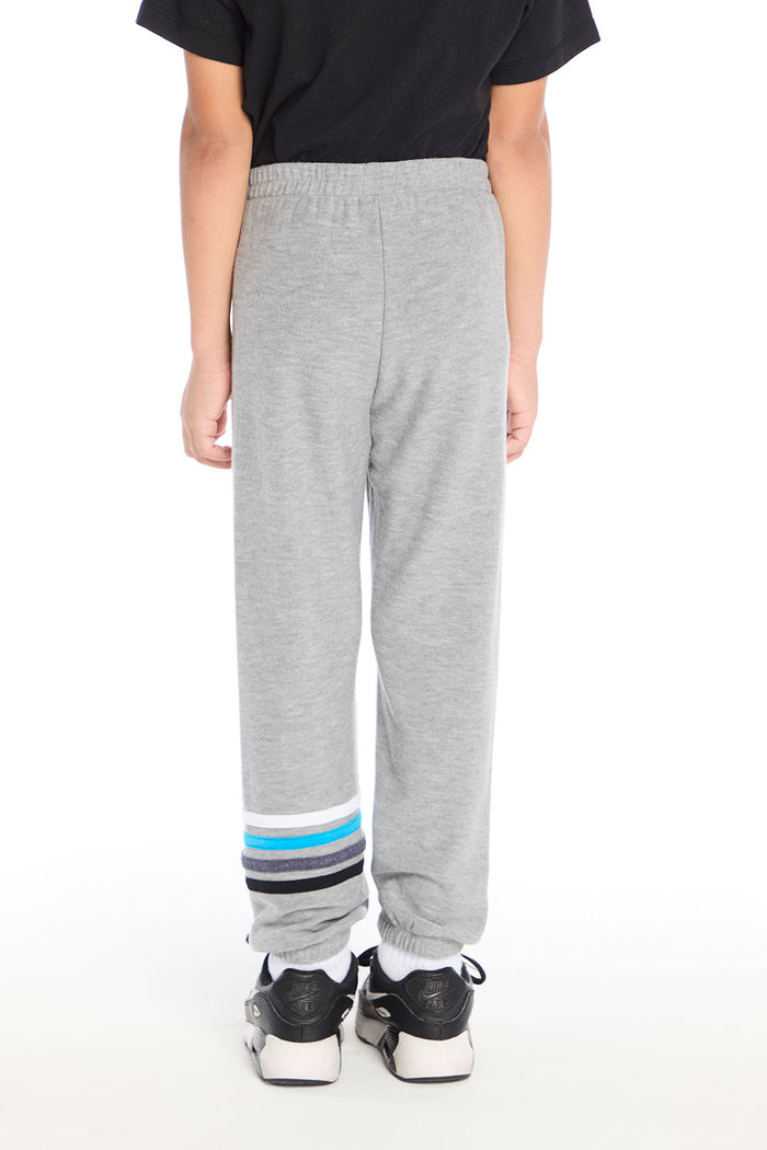 Back view of boy wearing Chaser Kids Heather Grey Joggers featuring elastic waistband and stripe cuff detail, styled with the Rolling Stones Dragon Tee on a white background