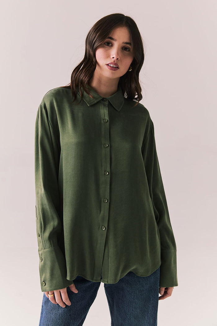 Front view of a model wearing the Helenaa button-down shirt in bronze green with collared neckline and relaxed silhouette,  against a plain background.