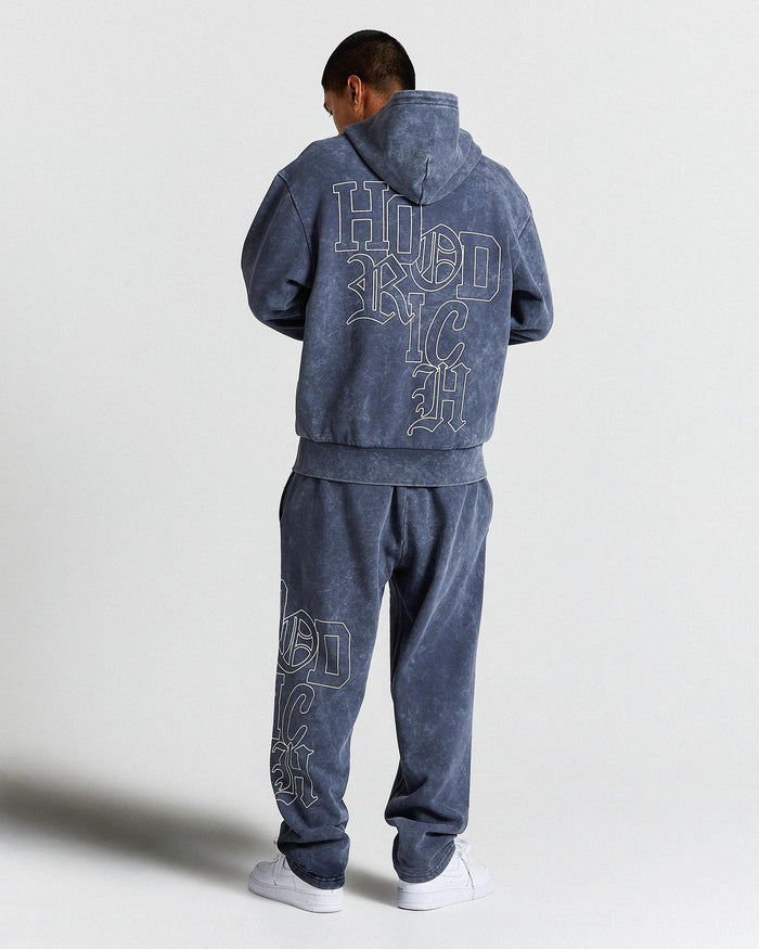 Person wearing a blue tracksuit with 'Hoodrich' text on the back against a white background
