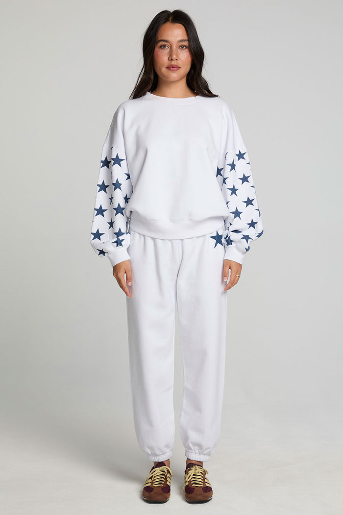 Full body front view of a woman wearing the Chaser High Spirits Long Sleeve on a neutral background with matching lounge pants