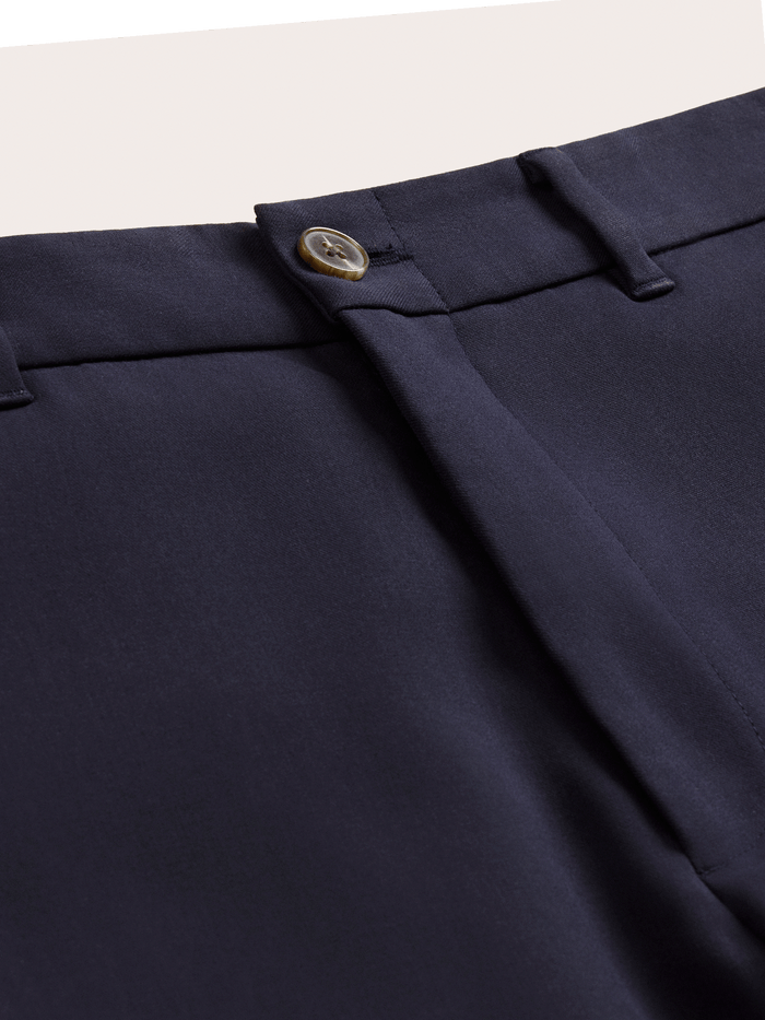 Close-up of admiral navy suit pants waistband, horn button and belt loops.