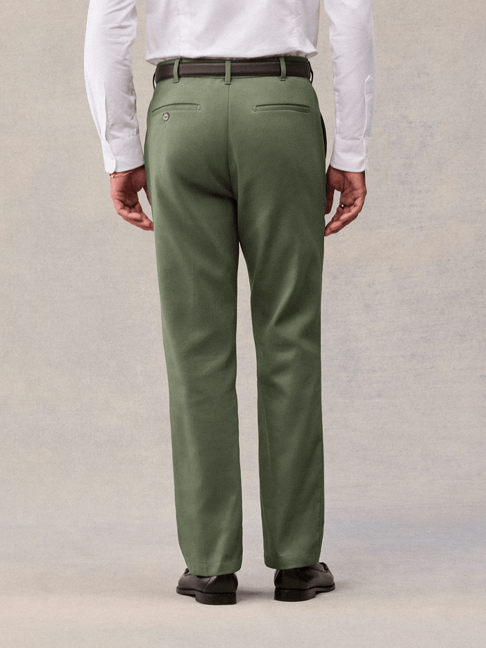 Dusty sage suit pants from behind, buttoned welt back pockets, cropped waist-to-shoe view.