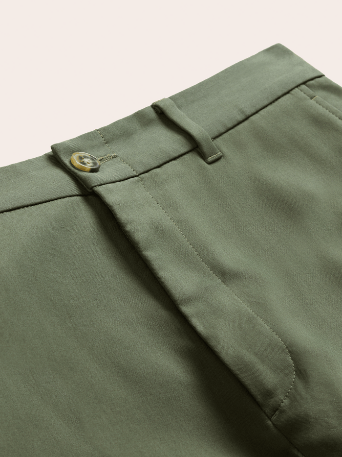 Close-up of dusty sage suit pants waistband, horn button and belt loops.