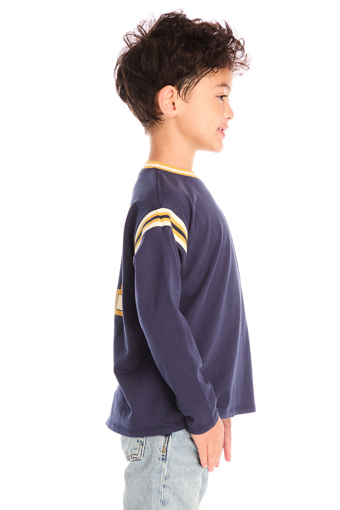 Side view of boy wearing Chaser’s I Am #1 navy long sleeve top with yellow stripes against a white background