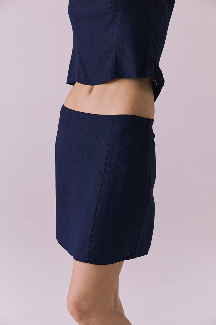 Side view of Chaser Ibiza Navy Mini Skirt highlighting sleek silhouette and minimal seams