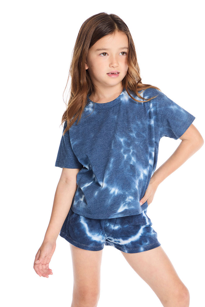 Girl wearing the Chaser Kids Indigo Heart Tie-Dye T-Shirt featuring a deep indigo hue with soft white tie-dye heart pattern and relaxed short sleeves