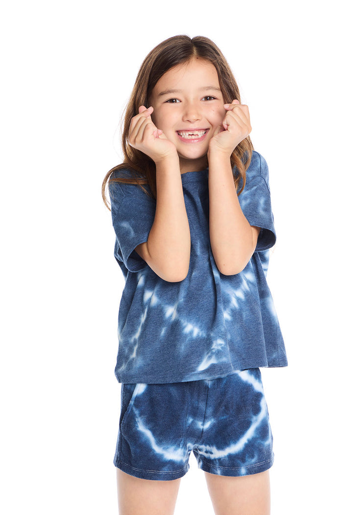 Girl wearing the Chaser Kids Indigo Heart Tie-Dye T-Shirt featuring a deep indigo hue with soft white tie-dye heart pattern and relaxed short sleeves